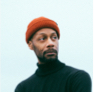 man with red beanie and turtleneck sweater