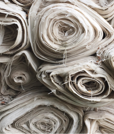 many large rolls of white sheets